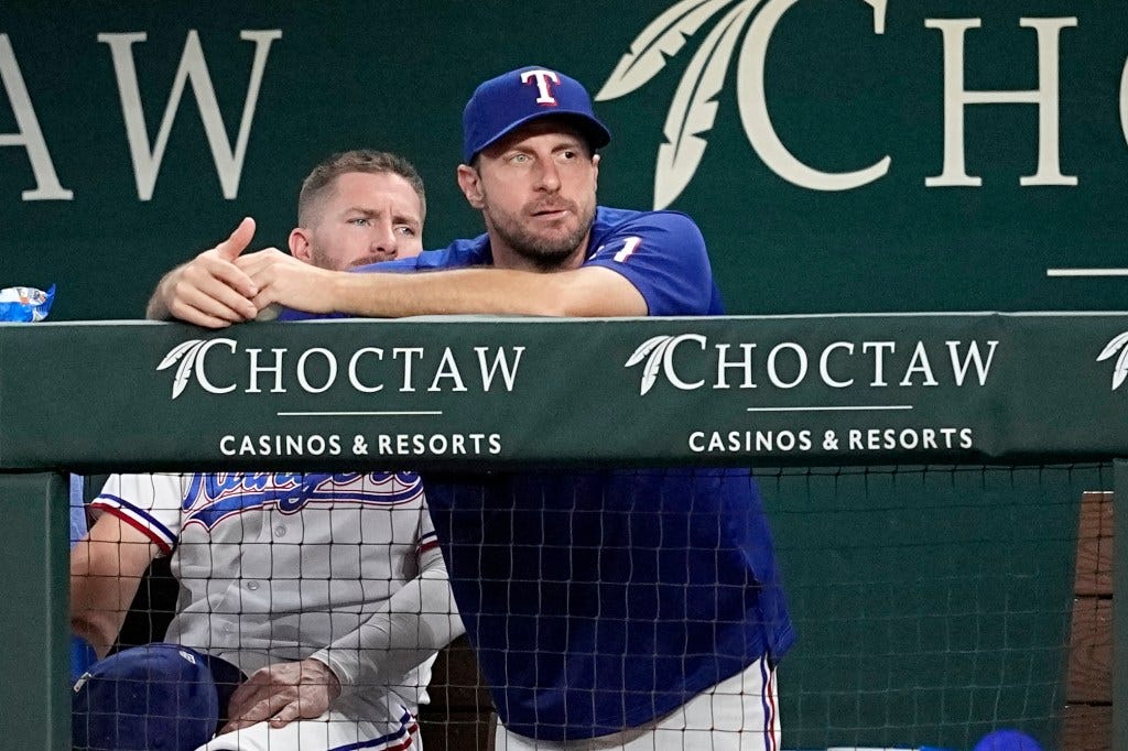 Rangers newly acquired pitcher Max Scherzer, center, watches play from the dugout