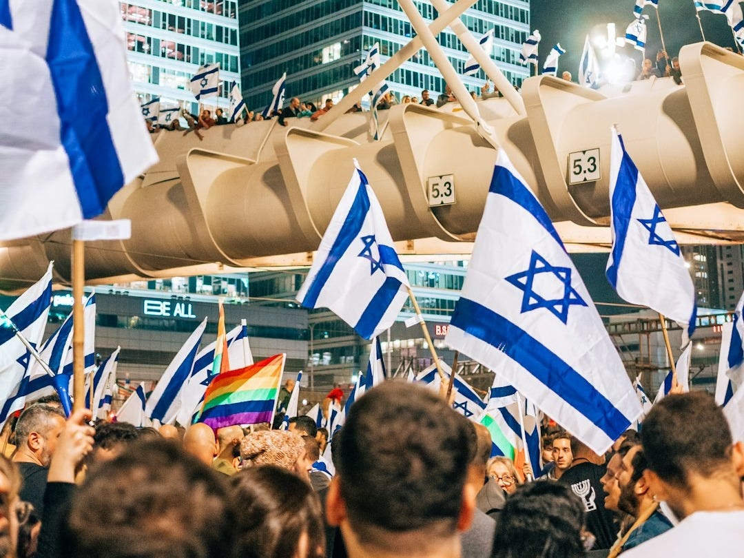 a large group of people holding israeli and israeli flags