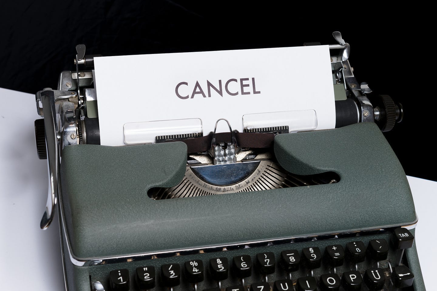 Photo of typewriter with a piece of paper in it that says, "Cancel"