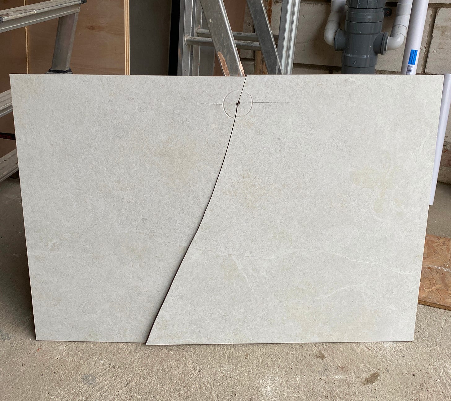 white tile with a large crack down the middle splitting it in two