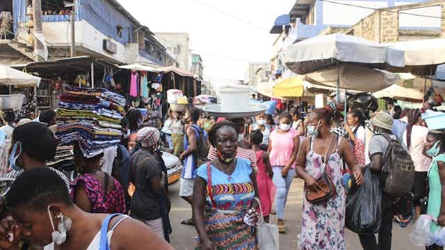 Men and women moving around in an open market
