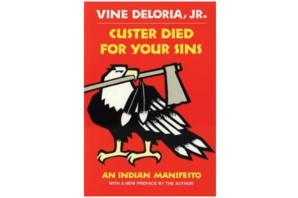 Cover of the book Custer Died for Your Sins by Vine Deloria Jr. Bald eagle drawn in solid black lines holding a hatchet in its mouth, against a flat red background