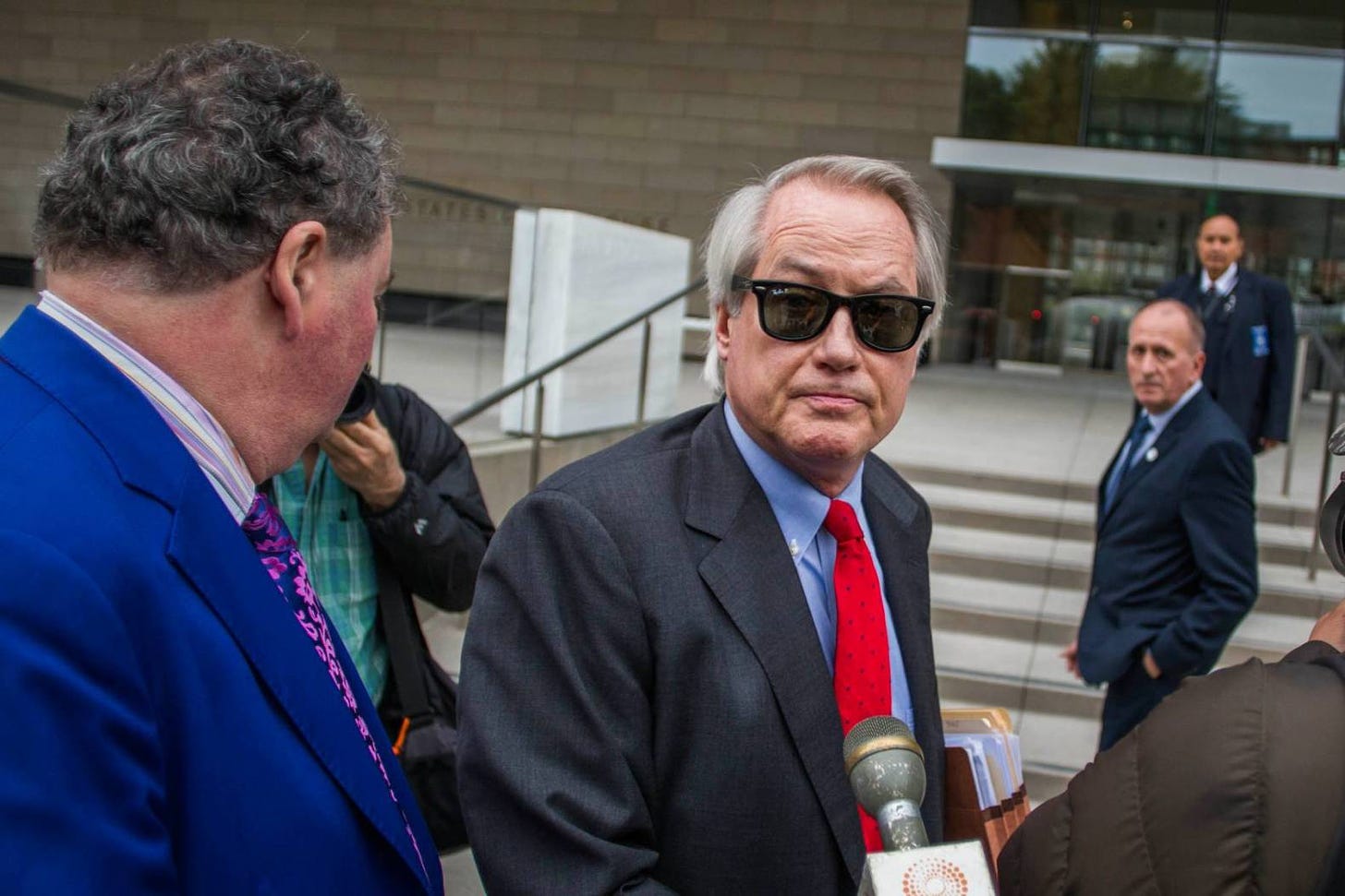 LOS ANGELES, CA - DECEMBER 03: Attorneys L. Lin Wood (C) and Mark Stephen (L) speak to the media about their client, British rescue diver Vernon Unsworth (rear), as they arrive at US District Court on December 3, 2019 in Los Angeles, California. Unsworth is suing Tesla CEO Elon Musk for defamation over calling him "Pedo Guy" and rapist. (Photo by Apu Gomes/Getty Images)