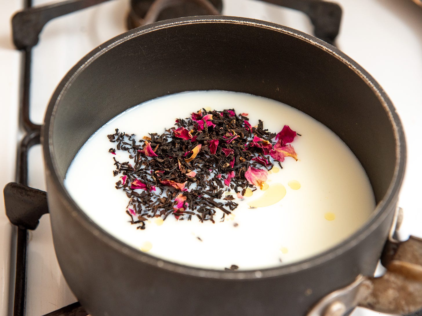 ID: Brewing black tea on the stovetop with water and milk