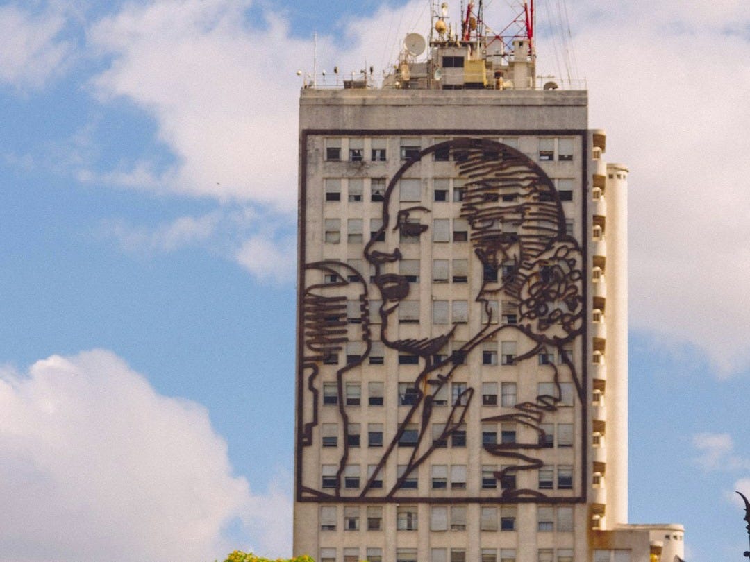 a tall building with a painting on the side of it a tall building with a painting on the side of it