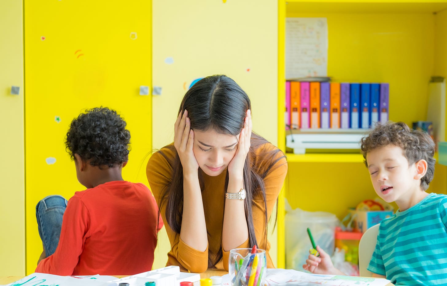 frustrated teacher with two kids acting up