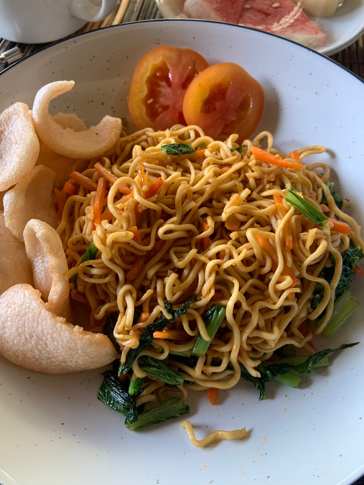 Stir fried egg noodles with spinach, carrots, and fresh tomatos 