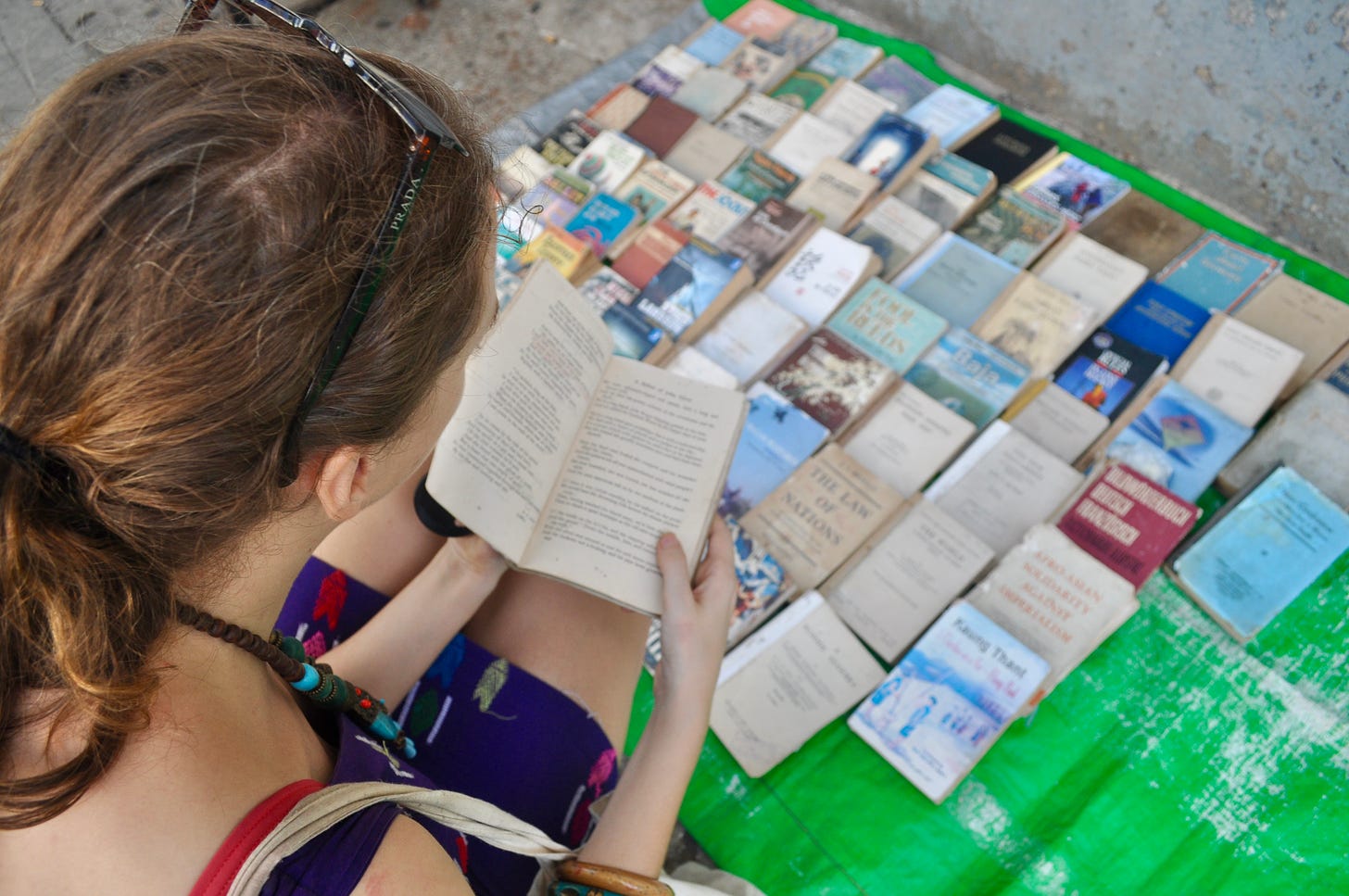 The author reading a book at a pavement used book stall. 