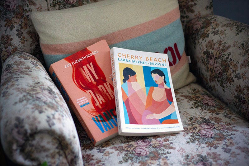 A copy of ‘My Dark Vanessa’ by Kate Elizabeth Russell and ‘Cherry Beach’ by Laura McPhee-Brown sit against a cushion on a chair.