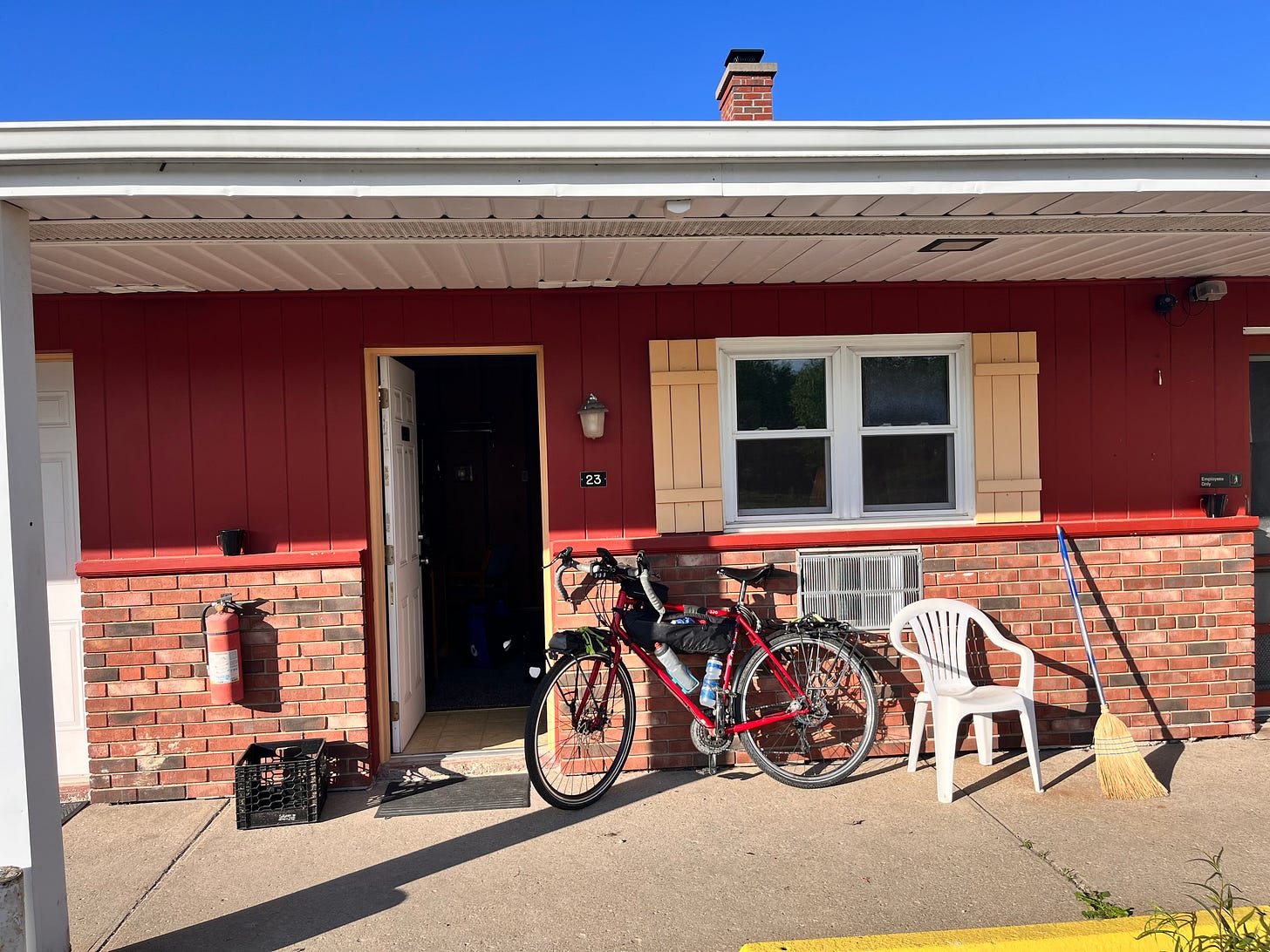 My red bike leaning against the wall of a motel room.