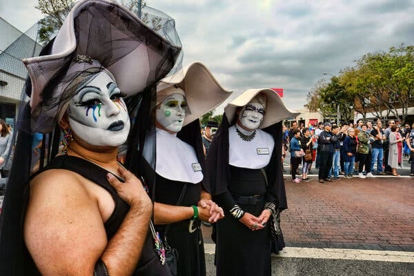 Members of the Sisters of Perpetual Indulgence, dressed in nun habits, attend a gay pride parade.