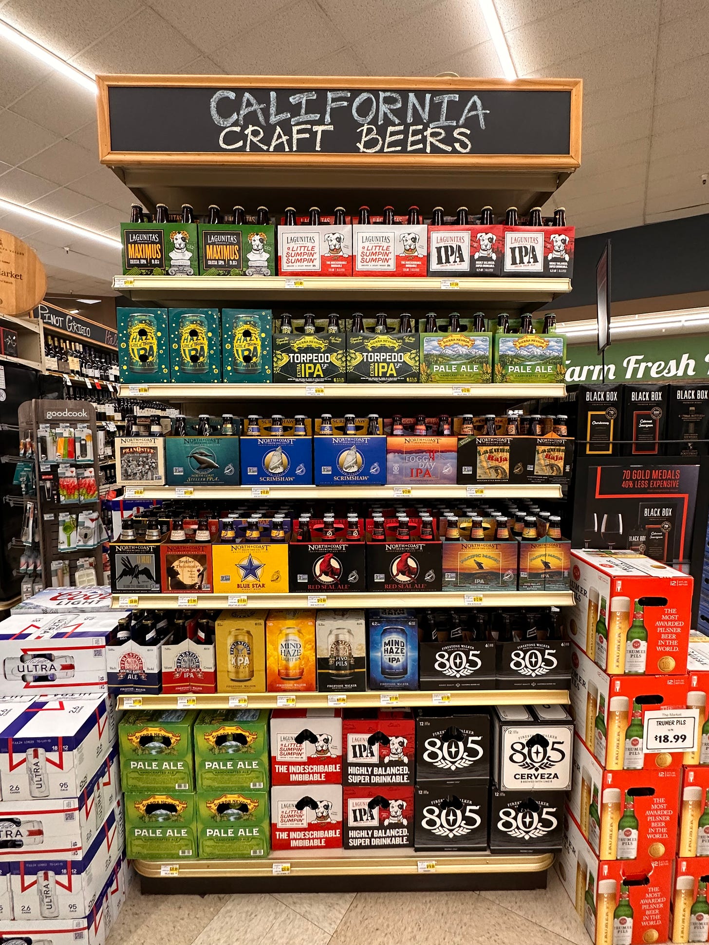 End display in a grocery store of California craft beers. Mostly bottles with some cans , six packs and 12 packs