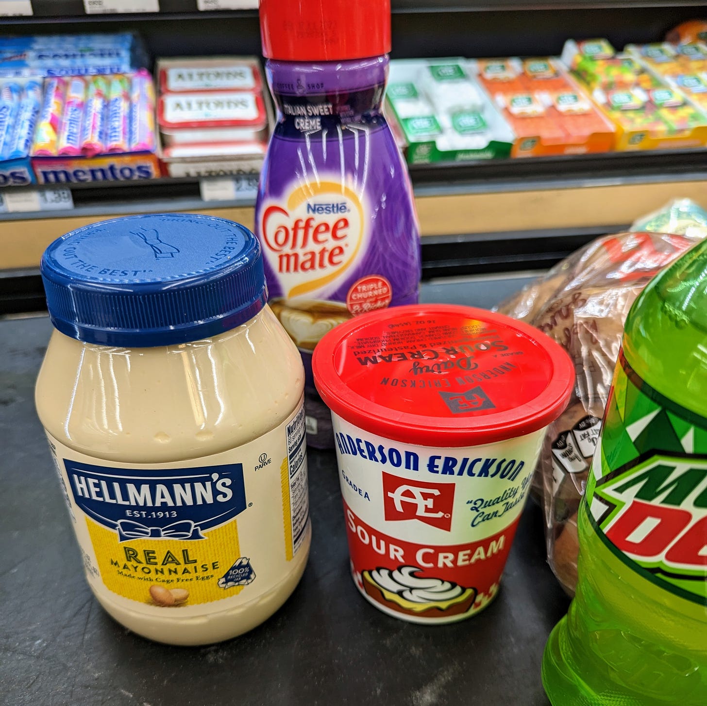 Mayo, sour cream, coffee creamer, mountain dew, and potatoes at a grocery store