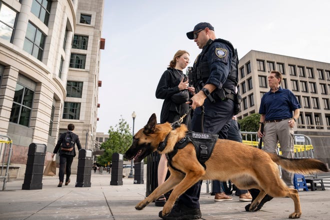 A police officer and a dog patrol the perimeter of the E. Barrett Prettyman United States Courthouse August 3, 2023 in Washington, DC.