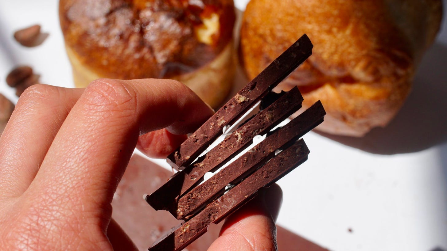 hand holding a stack of chocolate bar pieces