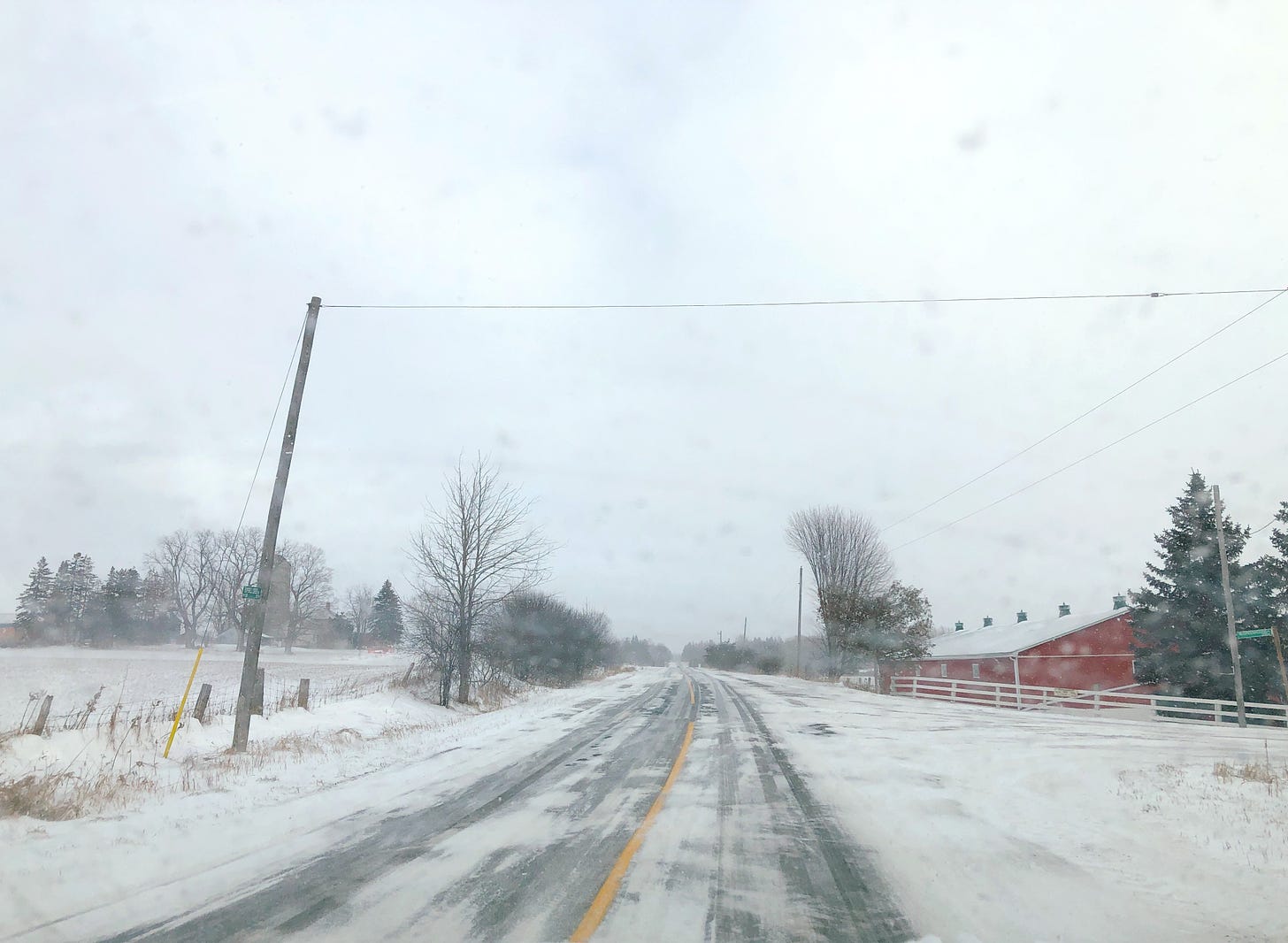 Red barn and a snow-covered road outside Guelph, Ontario, on Christmas Day 2022.