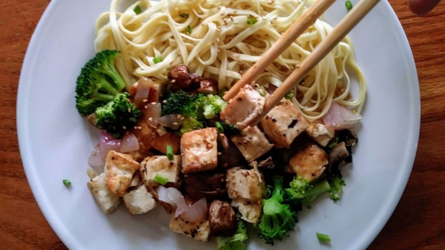 Sesame Ginger Tofu with Noodles on white plate with chopsticks.