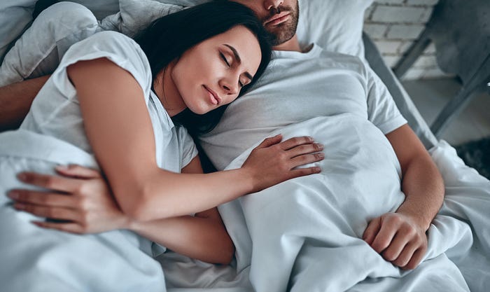 A woman sleeping next to a man. A woman sleeping next to a man.