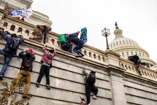 Several people climbing the walls outside the Capitol in Washington.