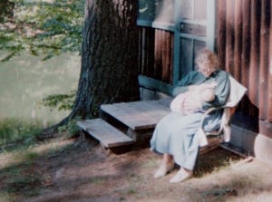 Sitting with my baby in front of Uncle Fred's cabin, barefoot and happy. 