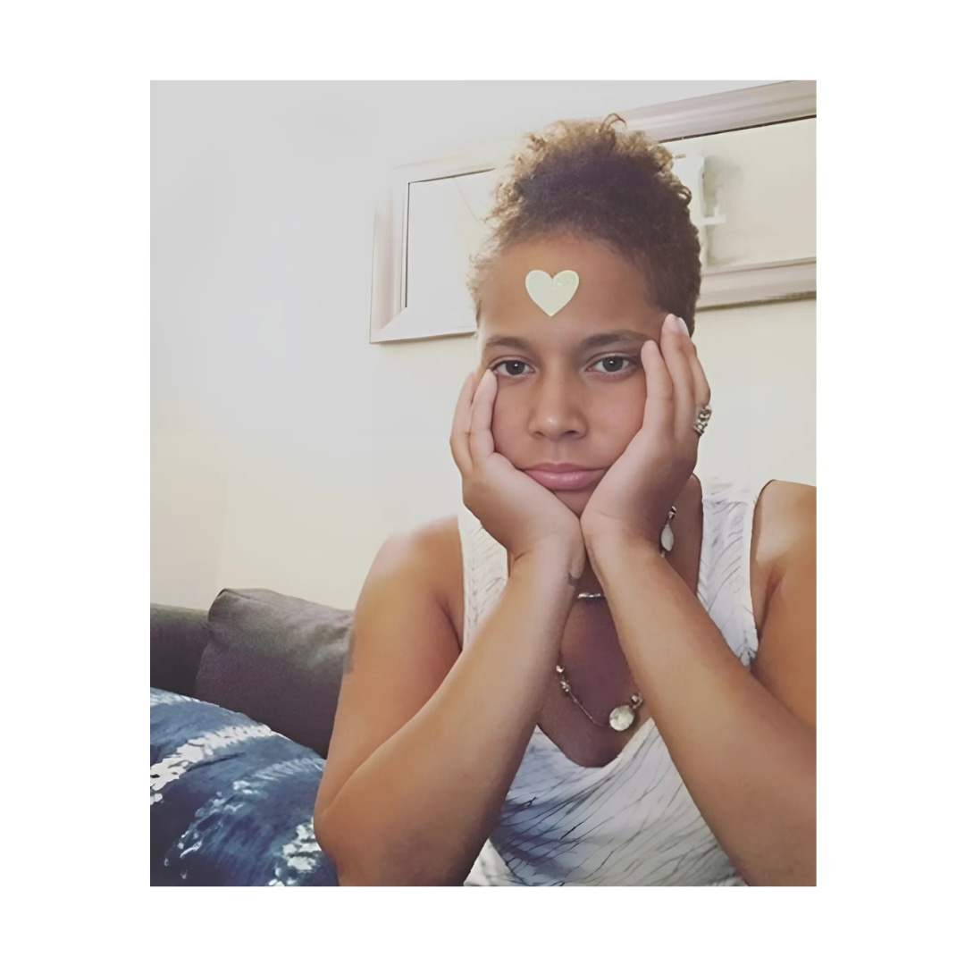 A picture of me looking dismal with a gold heart sticker on my forehead for no reason. 