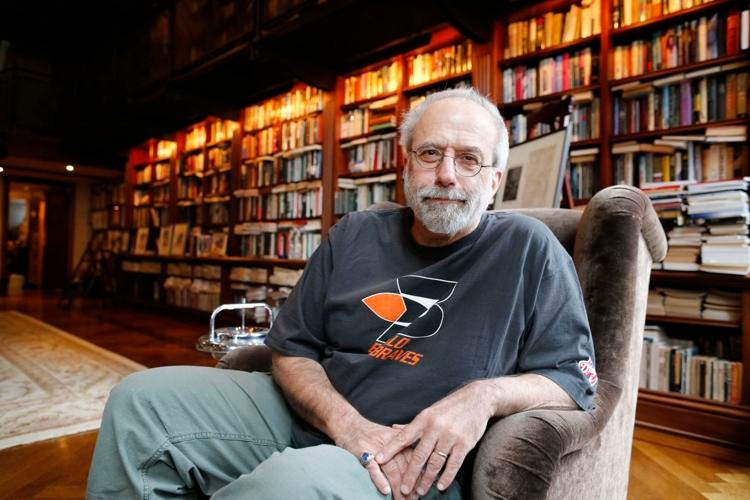 This photo shows Homicide: Life on the Street's showrunner & driving force Tom Fontana sitting in a chair inside his Greenwich Village home. Large, full bookshelves stretch away from Fontana toward the room's door. This photo shows Homicide: Life on the Street's showrunner & driving force Tom Fontana sitting in a chair inside his Greenwich Village home. Large, full bookshelves stretch away from Fontana toward the room's door.