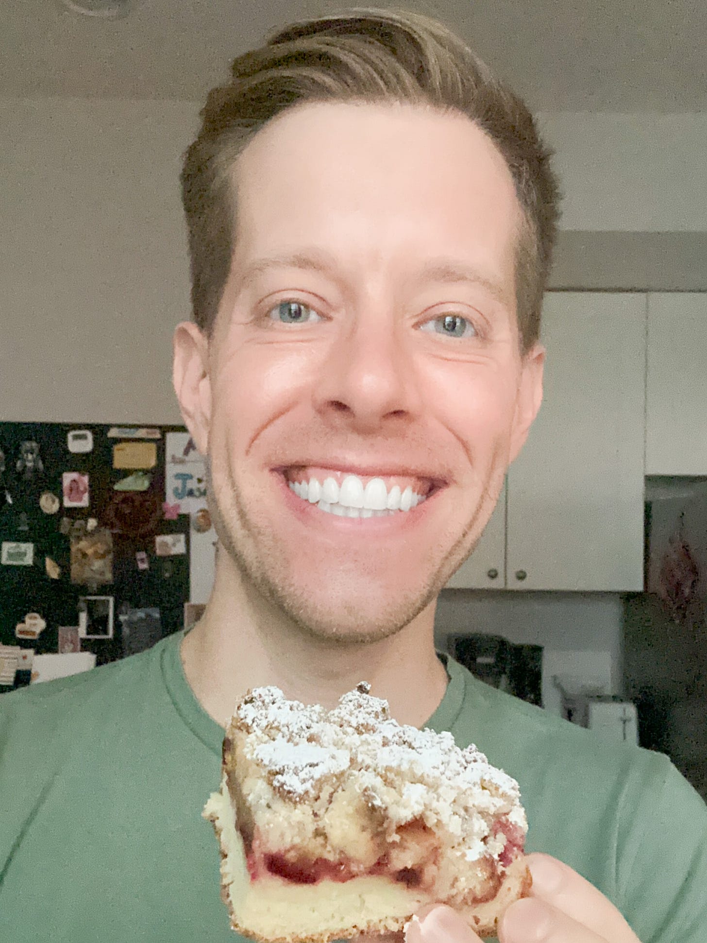 A photo of Martin smiling and holding a piece of plum cake.