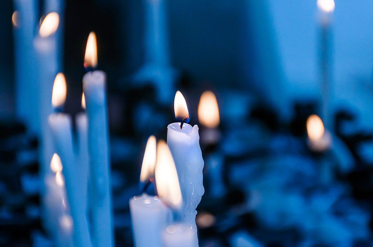 Lit white candles with a blue toned filter