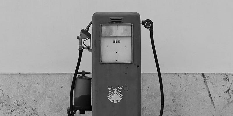 Old gas pump against a stone wall