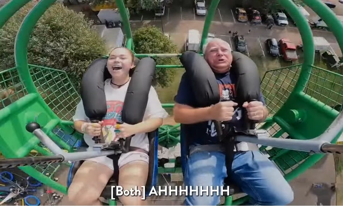 Video screenshot of Tim Walz and daughter Hope riding 'Slingshot' ride at Minnesota State Fair. Both are visibly forced backward by the ride's acceleration. The skin on Walz's face is slightly rippled by the G-force.