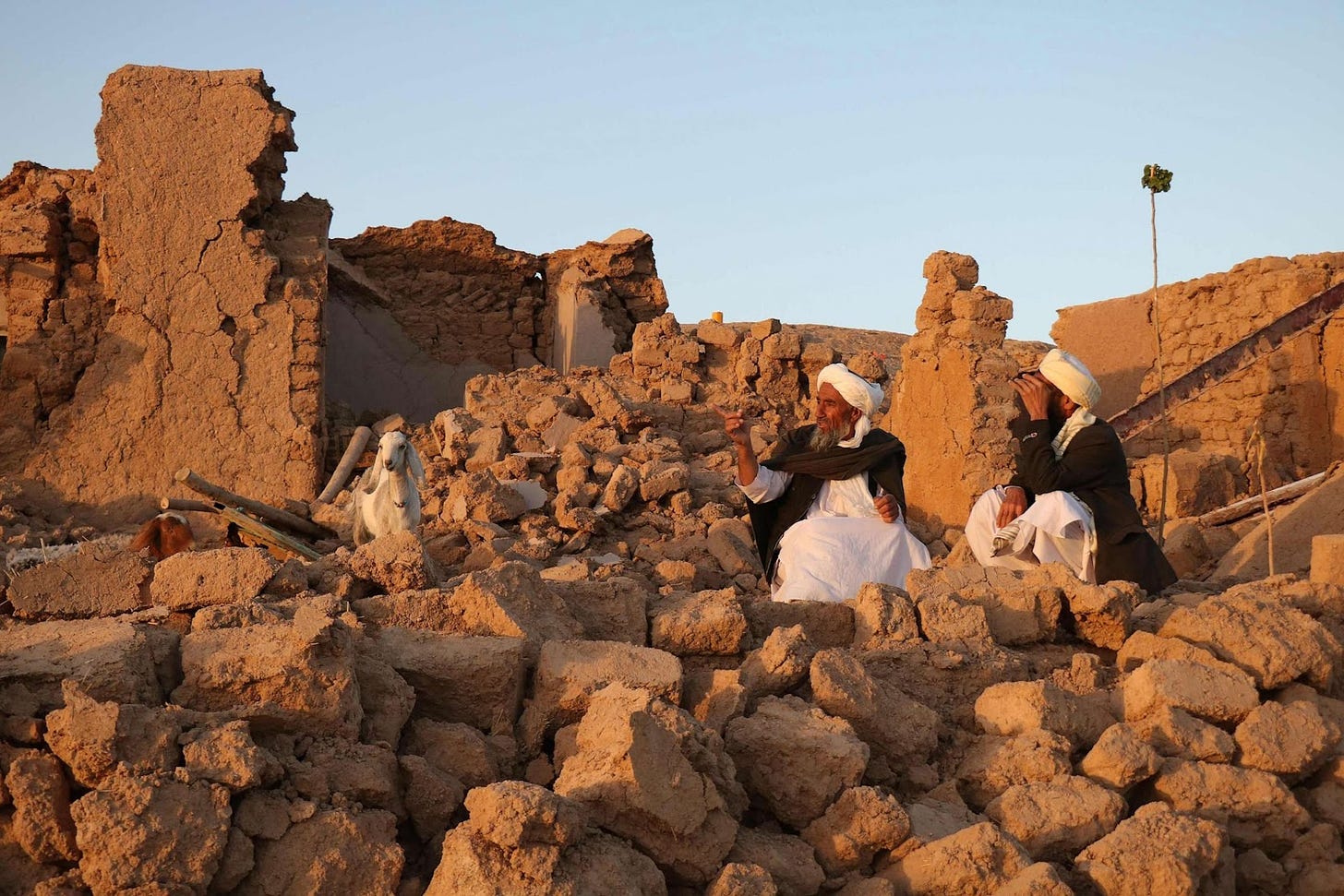 PHOTO: Afghan residents sit at a damaged house after earthquake in Sarbuland village of Zendeh Jan, district of Herat province, Afghanistan, on Oct. 7, 2023.