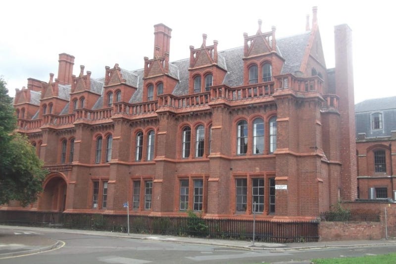 A large brick building with many windows

Description automatically generated