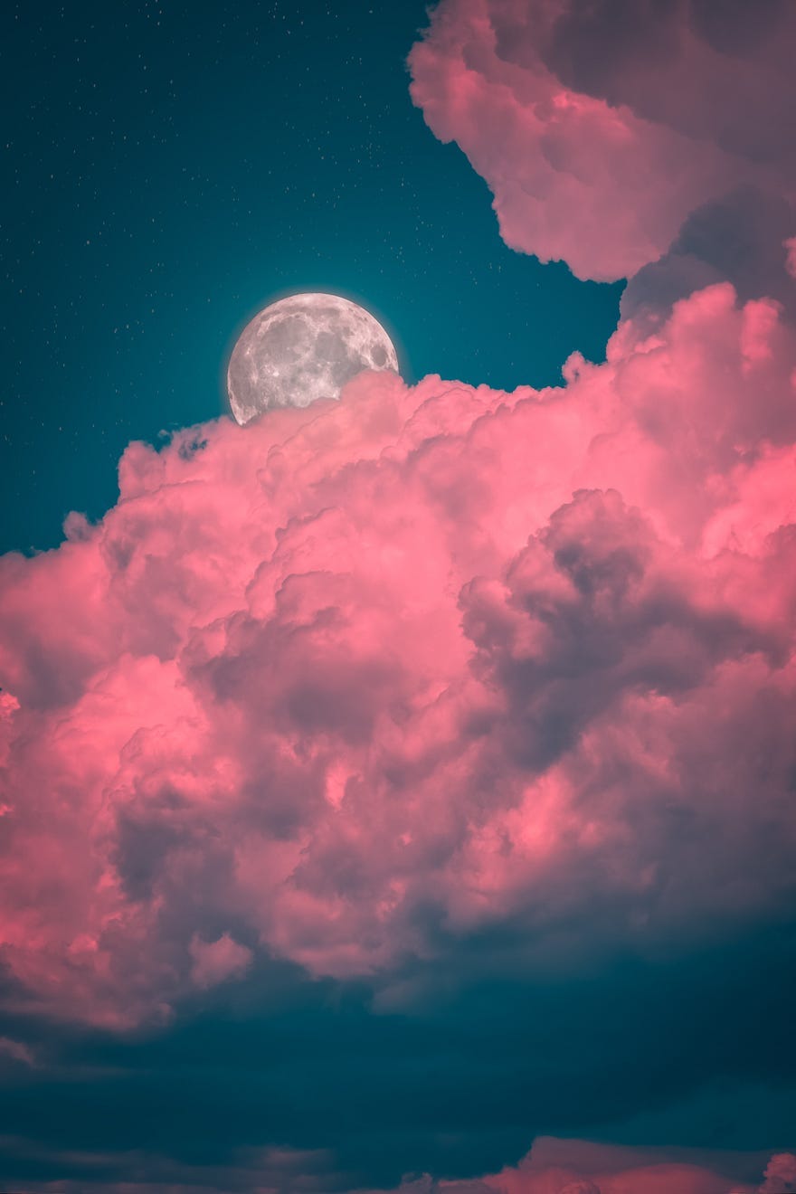 Moon behind pink clouds