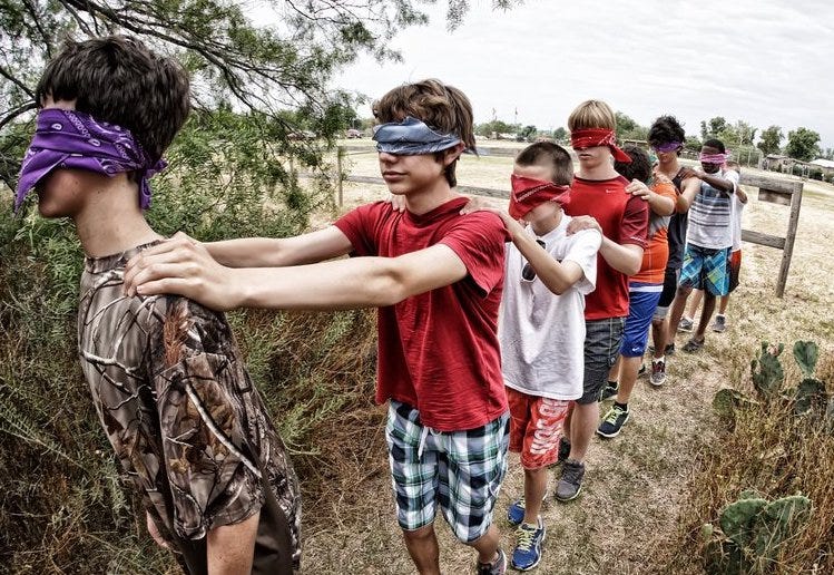 campers doing a blindfold walk together