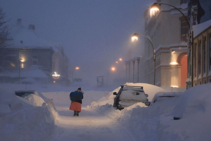 People fight their way through the snowstorm in Kristiansand, Norway, Wednesday, Jan. 3, 2024.