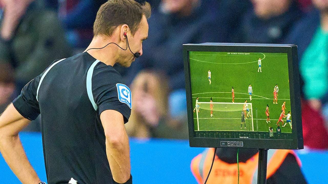 A referee looking into a VAR screen 