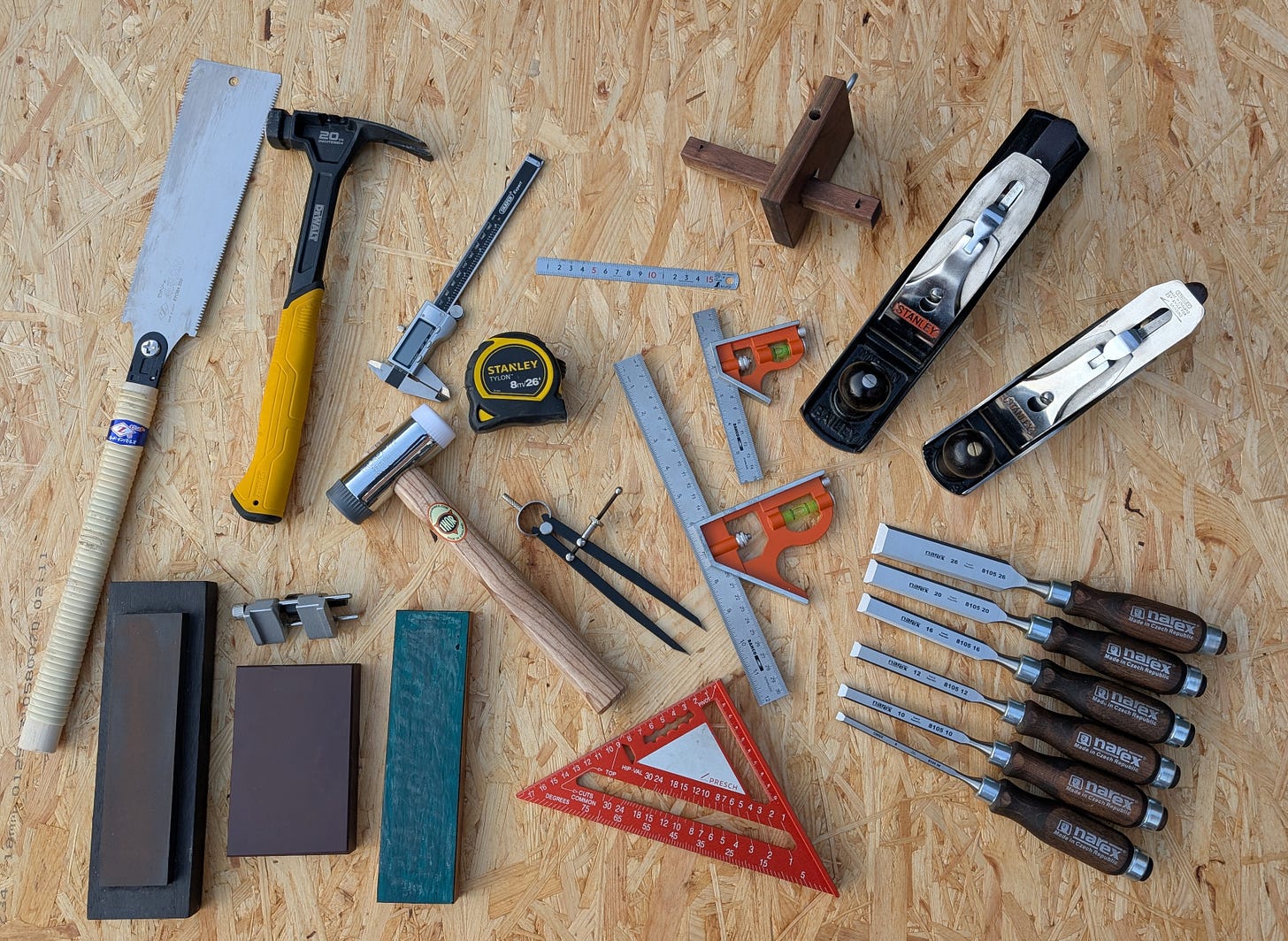 Complete beginner's woodworking toolkit laid out, showcasing essential hand tools.