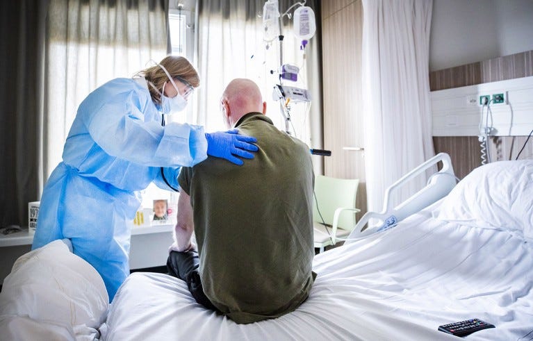 An attending physician listens to the breathing of a patient who is recovering after admission to an intensive care unit (ICU) in the coronavirus (COVID-19) patient nursing department of The HMC Westeinde Hospital in The Hague on April 4, 2020.