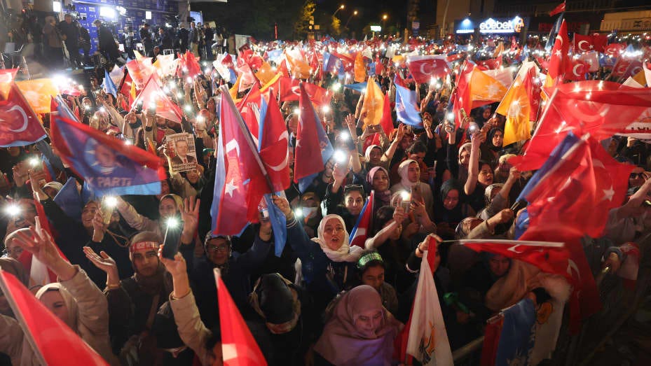 Supporters of Turkish President Tayyip Erdogan wave flags outside the AK Party headquarters after polls closed in Turkey's presidential and parliamentary elections in Ankara, Turkey on May 15, 2023.
