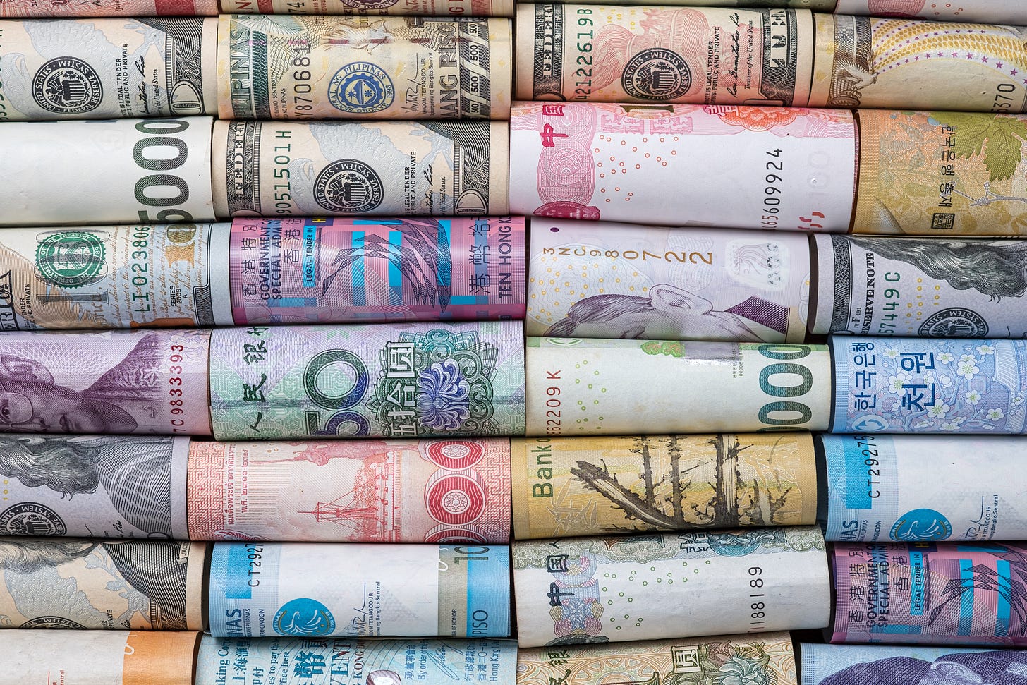 a collection of paper money in rolls from a wide variety of countries, various colors and patterns