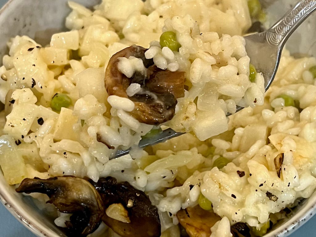 A close up photo of a fork full of delicious looking risotto.