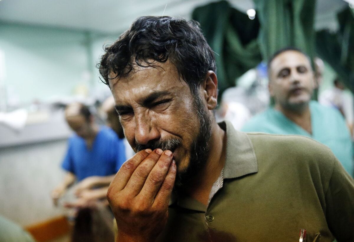 A Palestinian man cries after bringing a child, wounded during fighting between Israeli forces and Hamas militants, to the emergency room room.