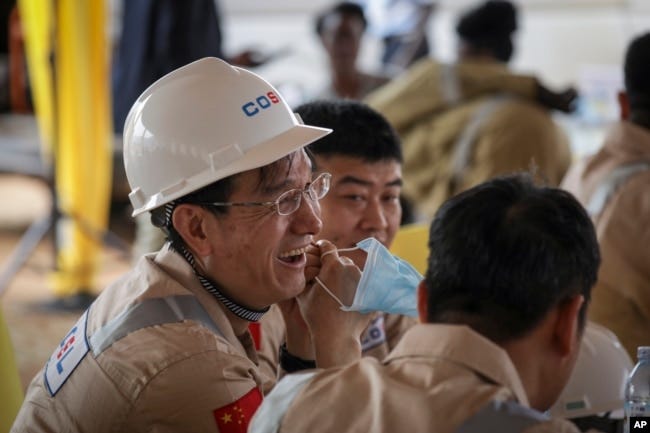 Chinese workers from China Oilfield Services Limited (COSL) begin drilling at the Kingfisher oil field on the shores of Lake Albert in the Kikuube district of western Uganda Tuesday, Jan. 24, 2023. (AP Photo/Hajarah Nalwadda)
