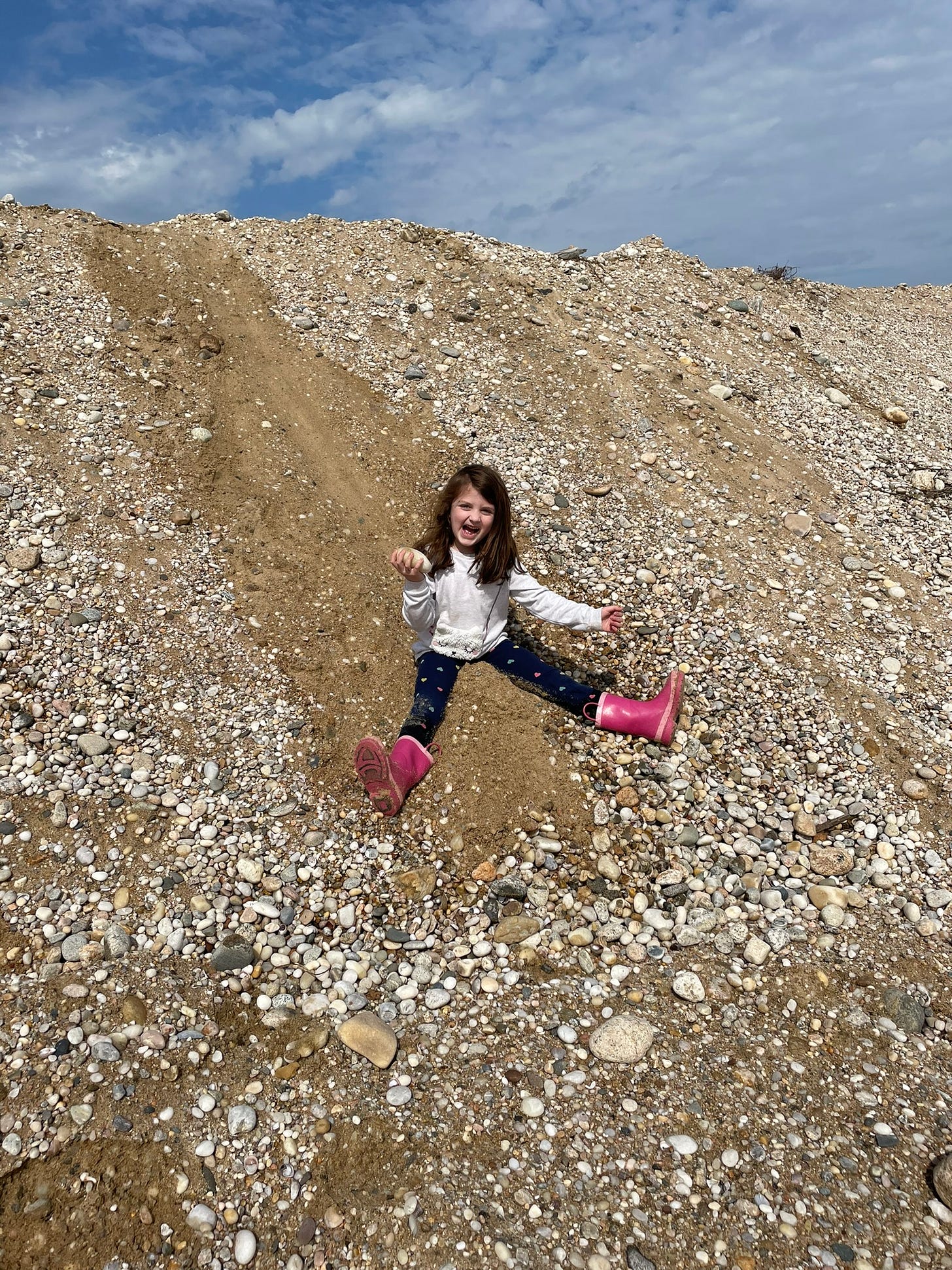 Child sliding down sand dune