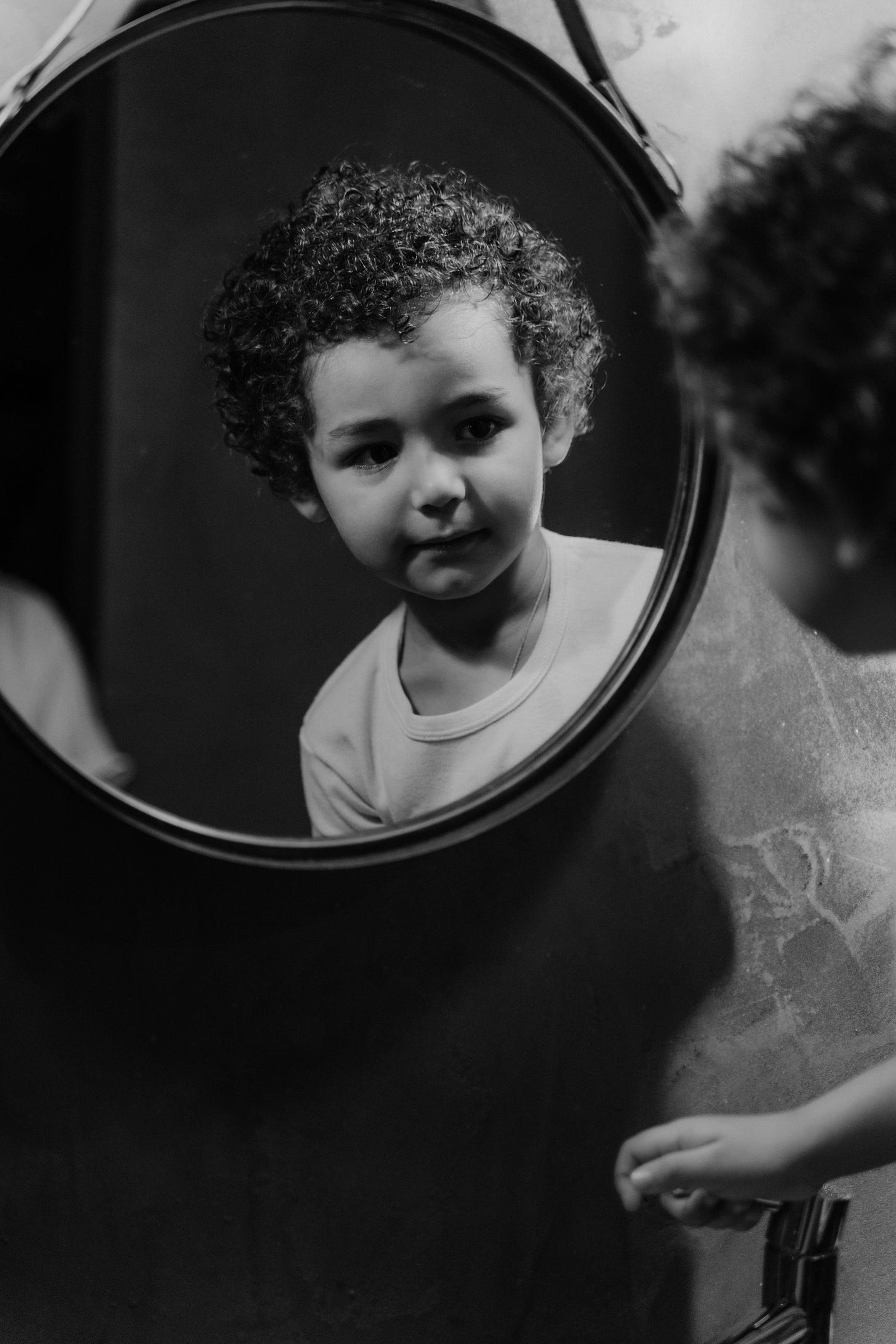 Free Grayscale Photography of a Kid Looking at the Round Mirror Stock Photo