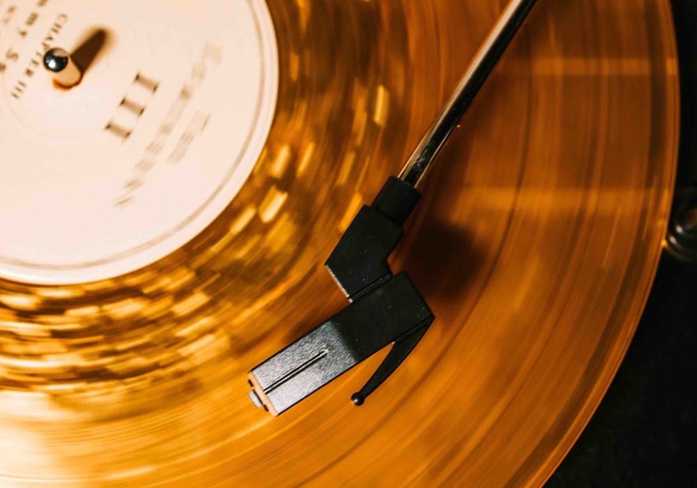Gold record spinning on vintage record player illustrating how vibrational frequency is cycles per second