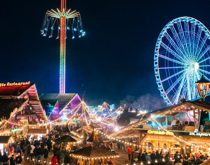 Winter Wonderland at night, with cabins and fariground rides illuminated