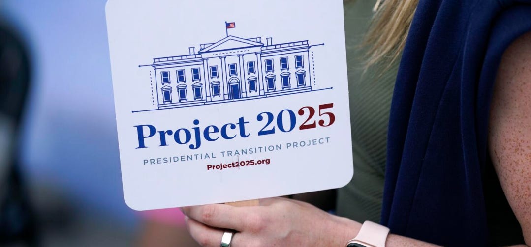 A supporter holds a Project 2025 fan in the group’s tent at the Iowa State Fair on Aug. 14, 2023. (Photo cred: Charlie Neibergall / Associated Press)