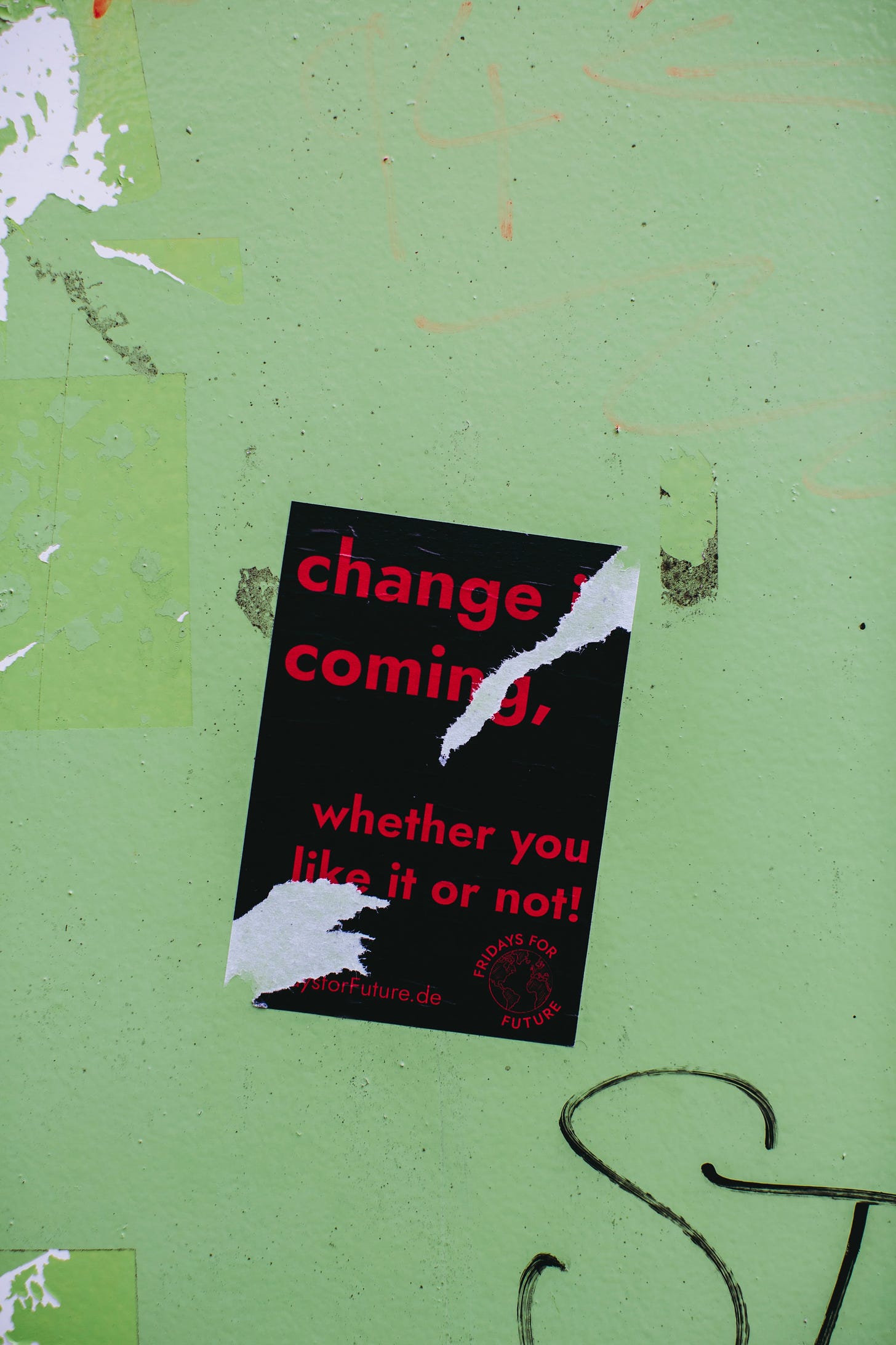 A ripped poster that says "change is coming whether you like it or not"