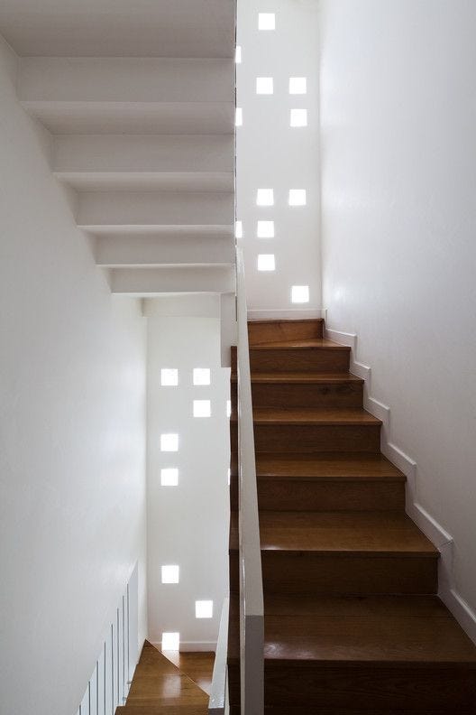 This may contain: the stairs are made of wood and have white walls This may contain: the stairs are made of wood and have white walls